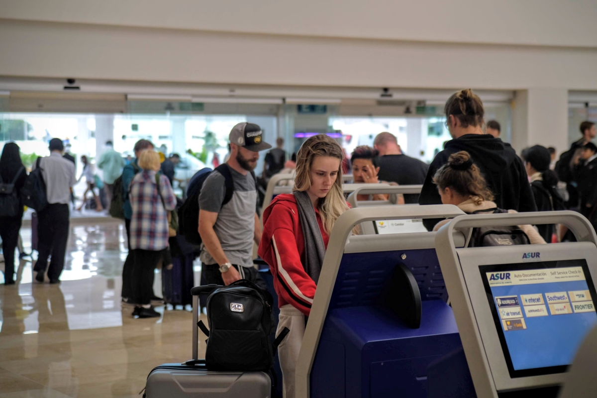 Pasajero usando un quiosco en el aeropuerto internacional de Cancún
