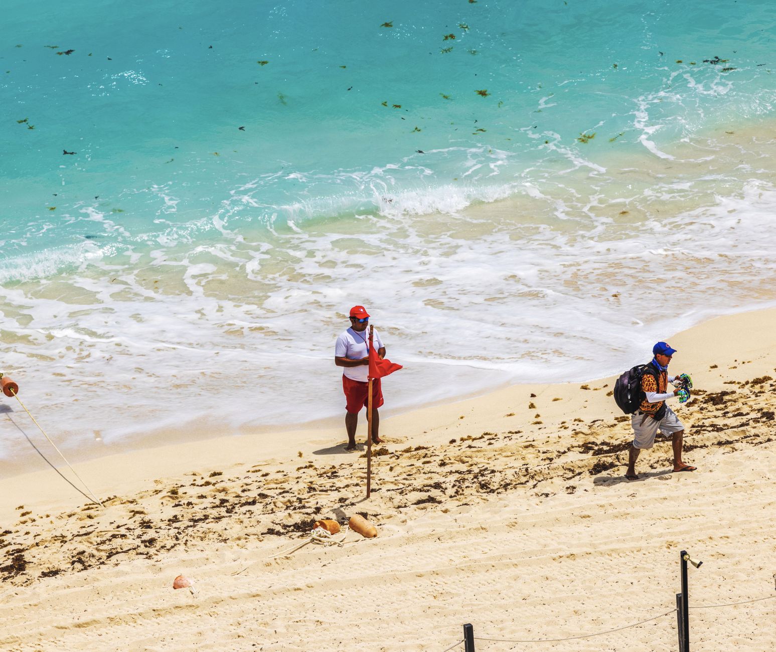 Salvavidas destaca bandera roja en playa de Cancún
