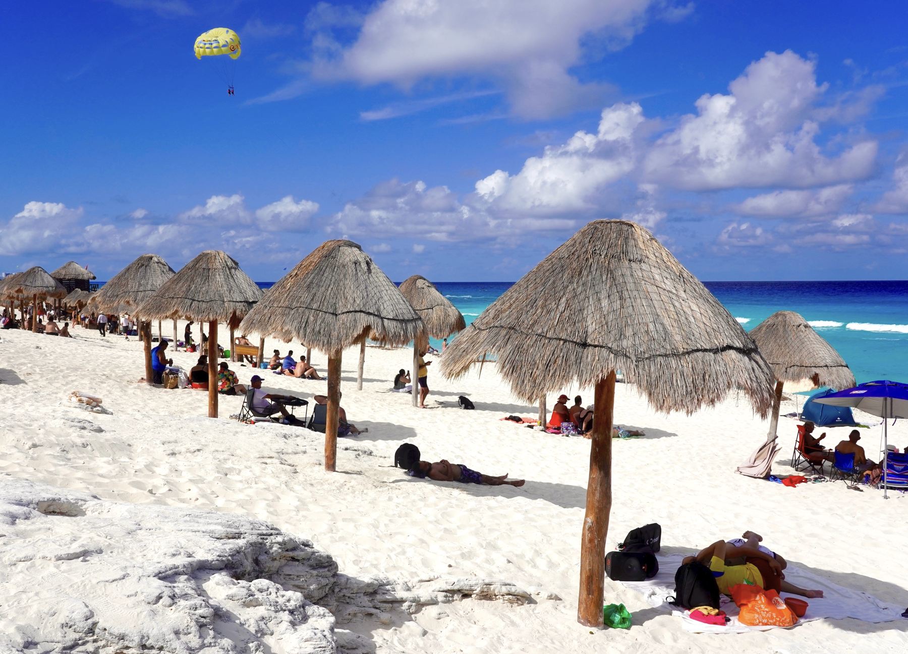 Palapas de playa y turistas en Beautiful Day Playa Delphines