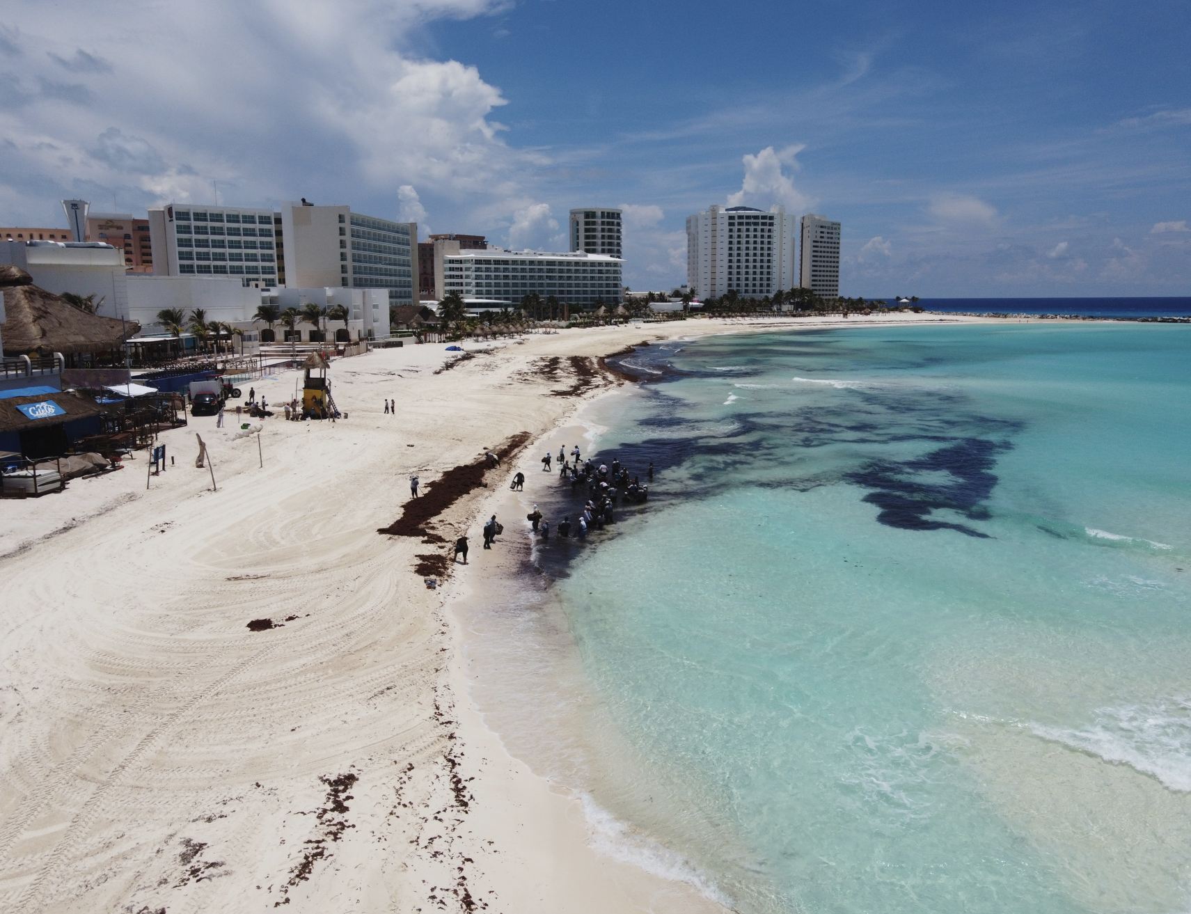 Ancun, Quintana Roo, México, 12 de junio de 2020.- Los trabajadores limpian a Sargassum en una playa en Cancún, la mancha de Sargassum se puede ver desde el aire