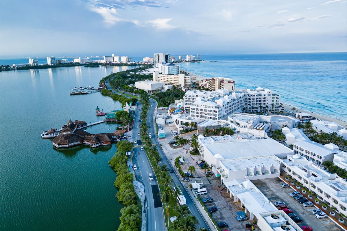 Disfruta de la impresionante vista diurna de hoteles y residencias que recubren a Nichupté Lagoon. Las tranquilas aguas reflejan la arquitectura, creando hermosos reflejos que capturan la esencia de Cancún