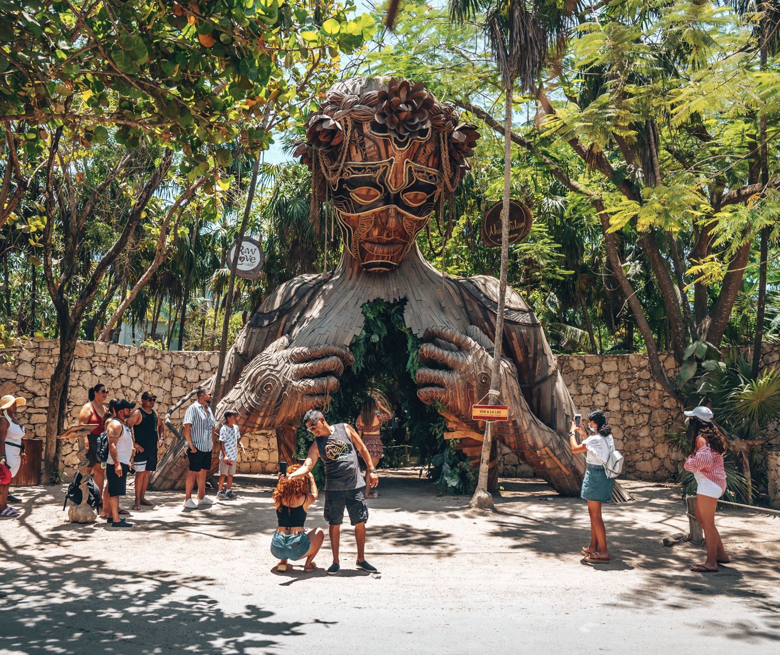 Los turistas de playa fotografiando frente a Ven a la Luz Escultura instalada en el resort Ahau