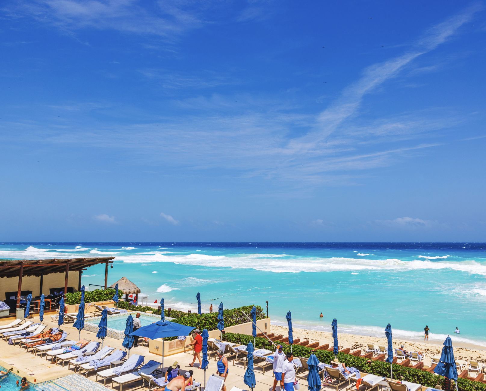 Los turistas se relajan en piscina en la playa en Cancún