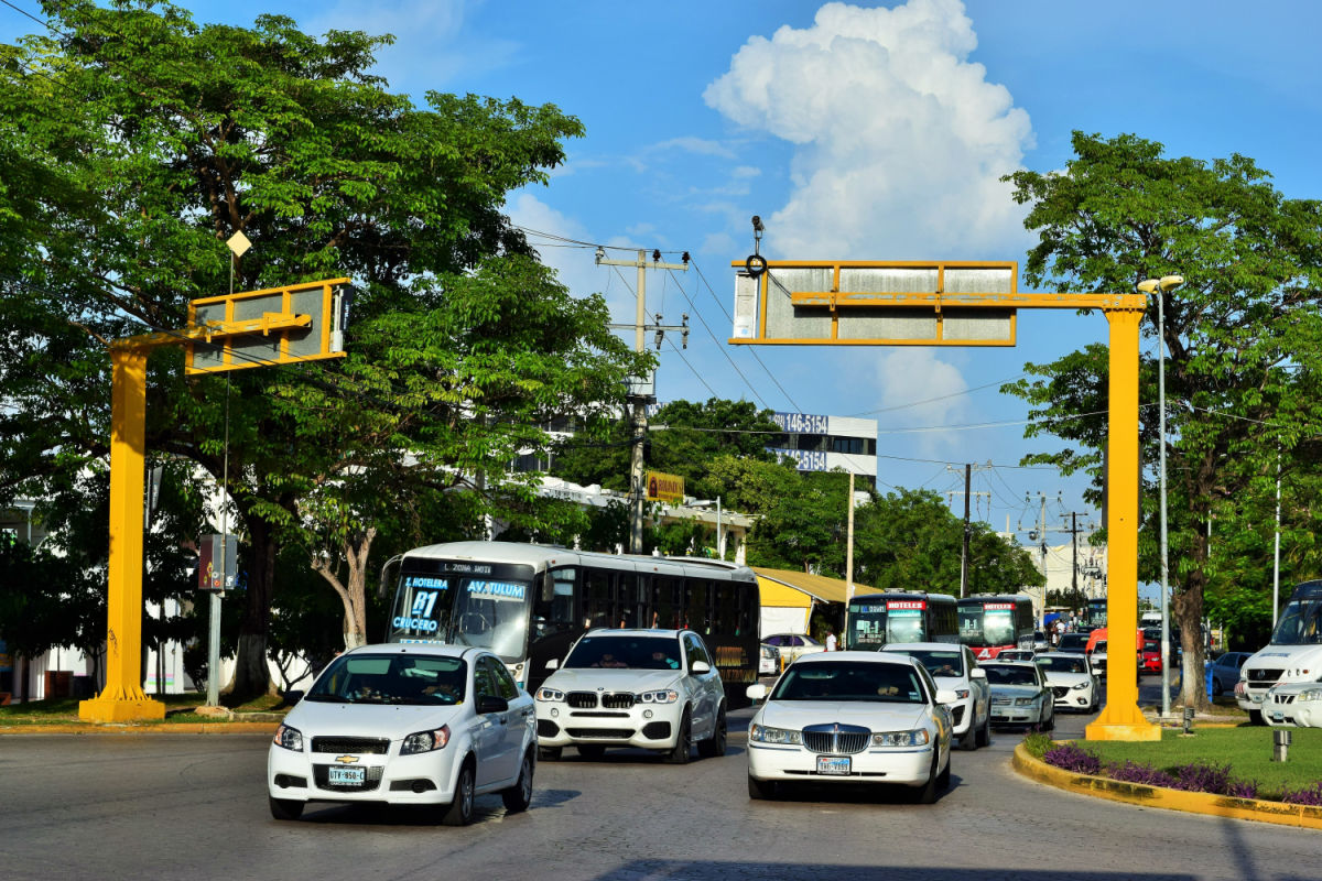 Autos en una calle arbolada en Cancún, México