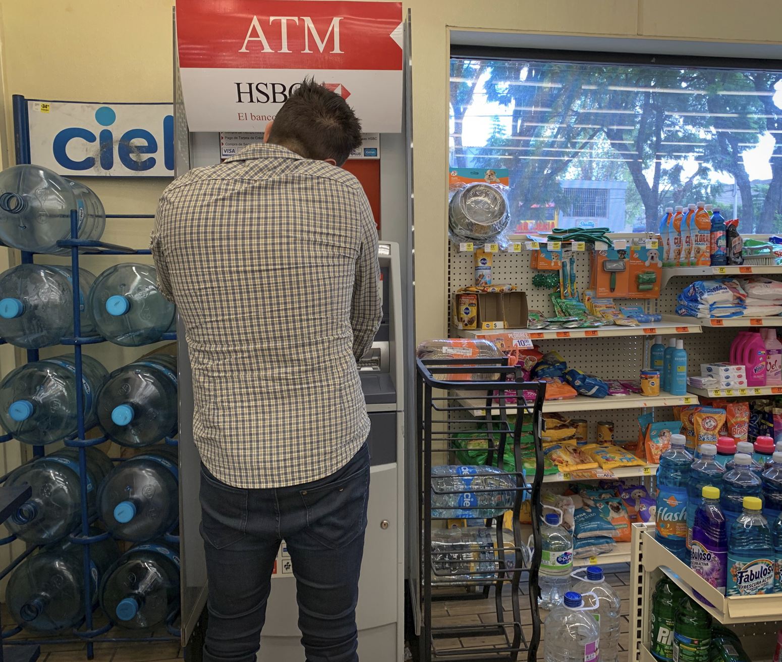 El turista usa la máquina bancaria en Oxxo