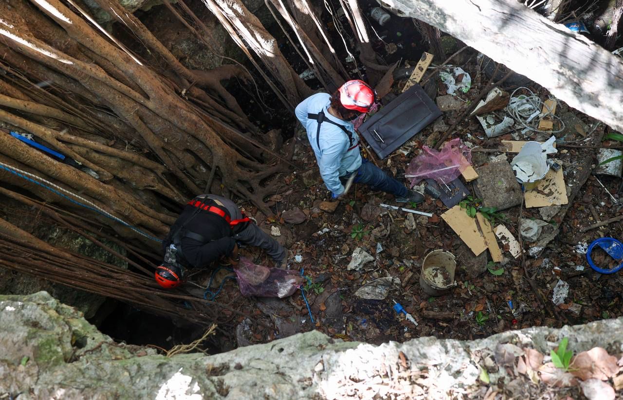 Hombre limpiando cenote en el fondo