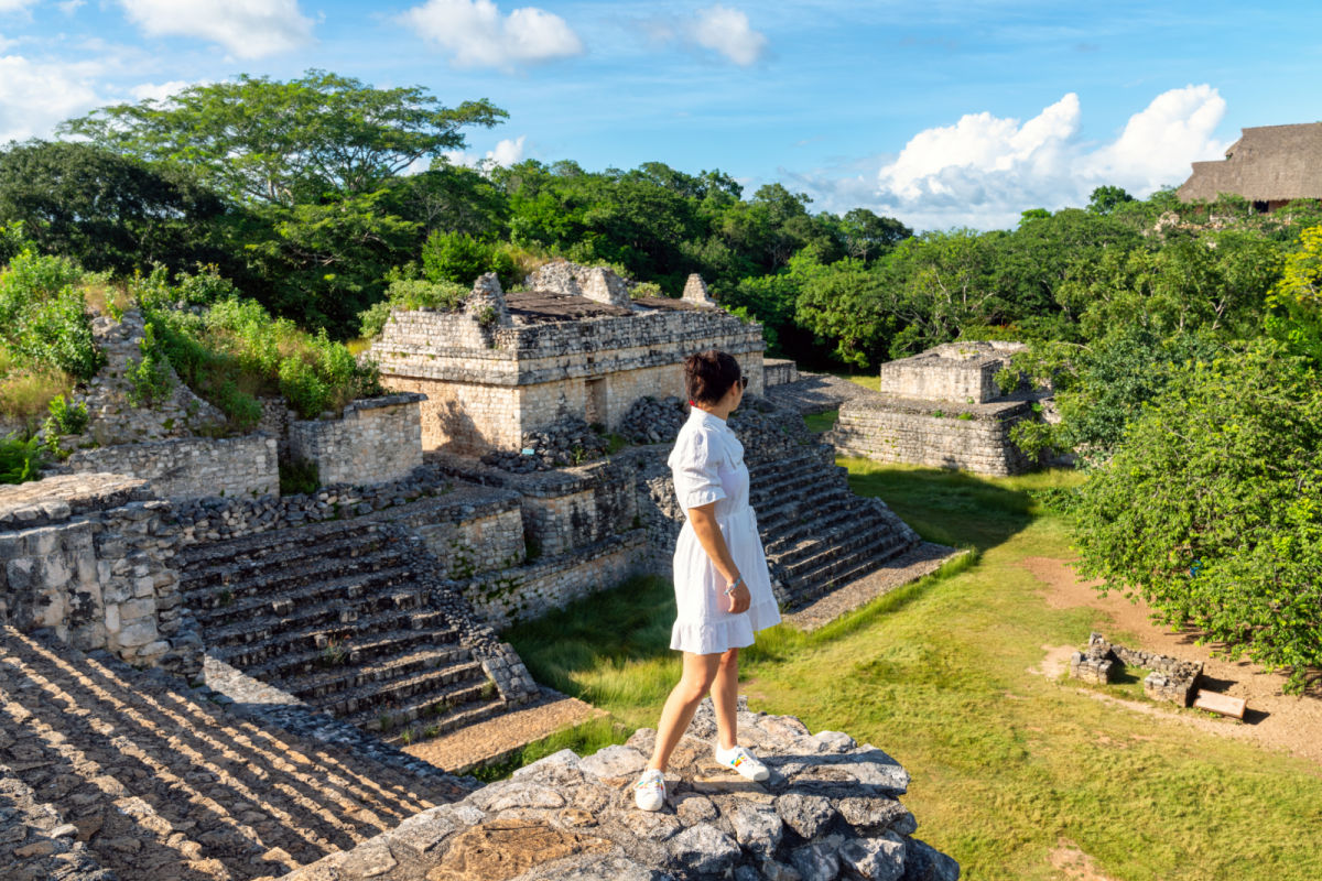 Ek Balam Mayan ruina en México con una mujer parada en las ruinas