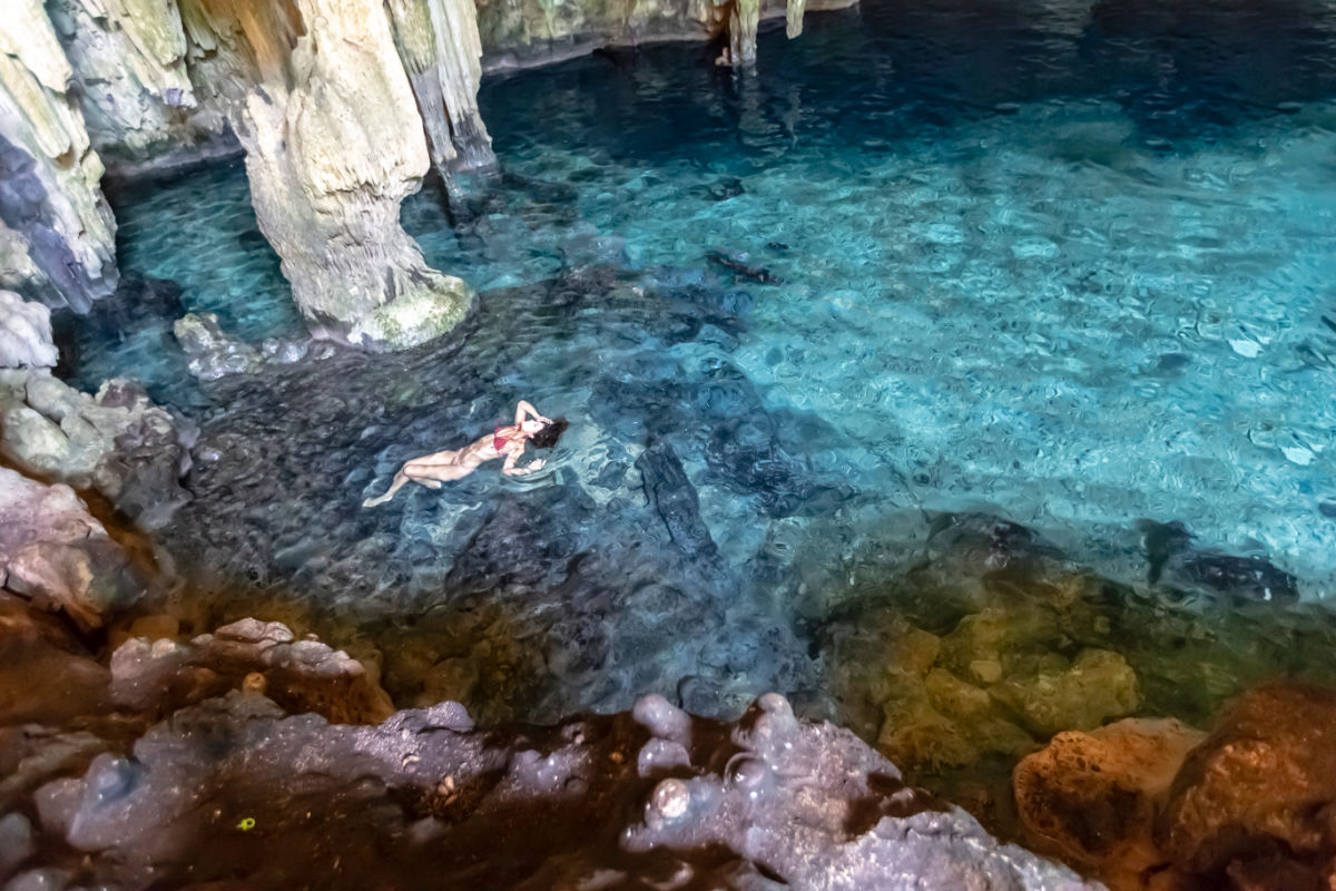 Mujer flotando en un cenote