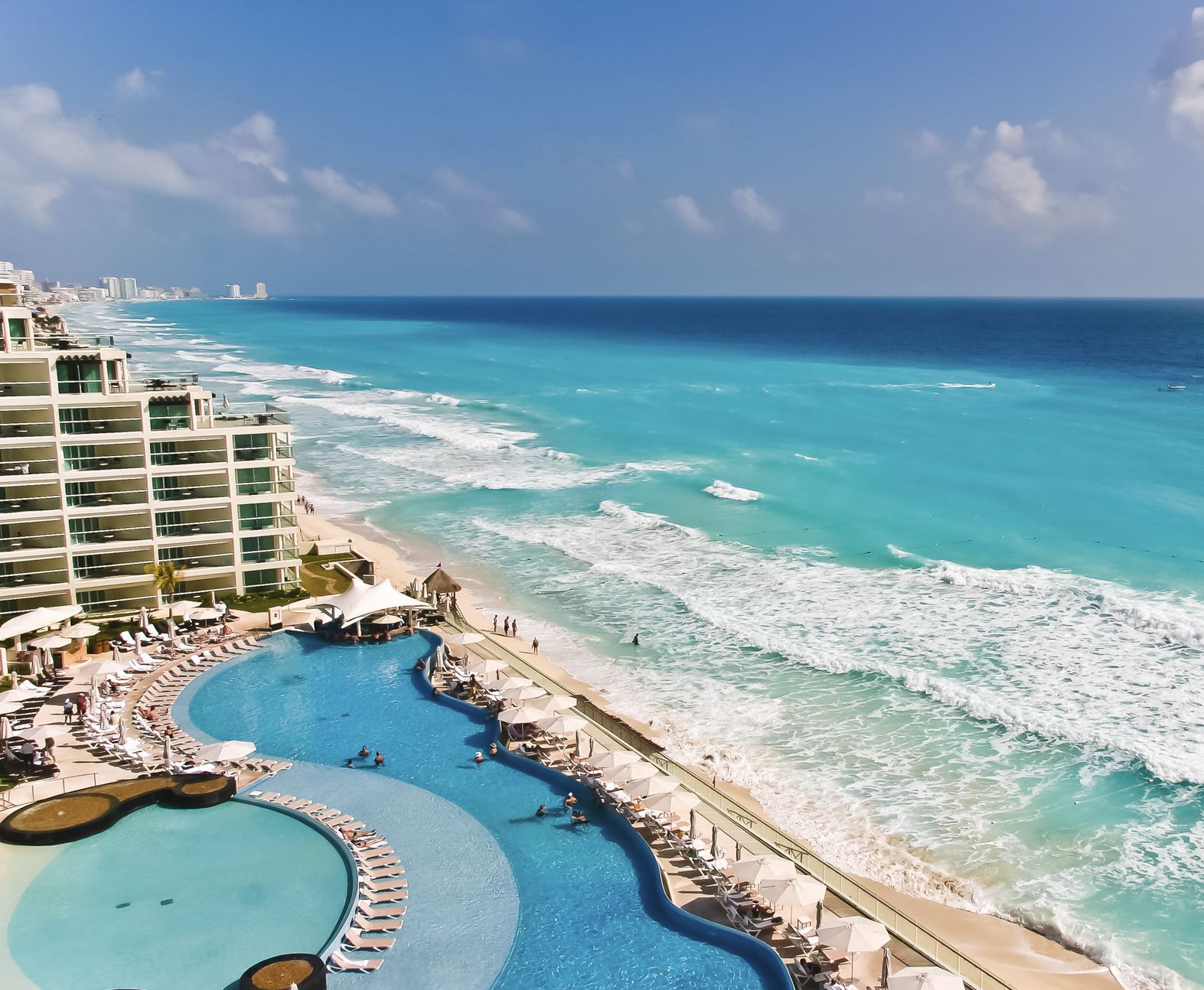 Camastros en la piscina de Cancún frente al mar