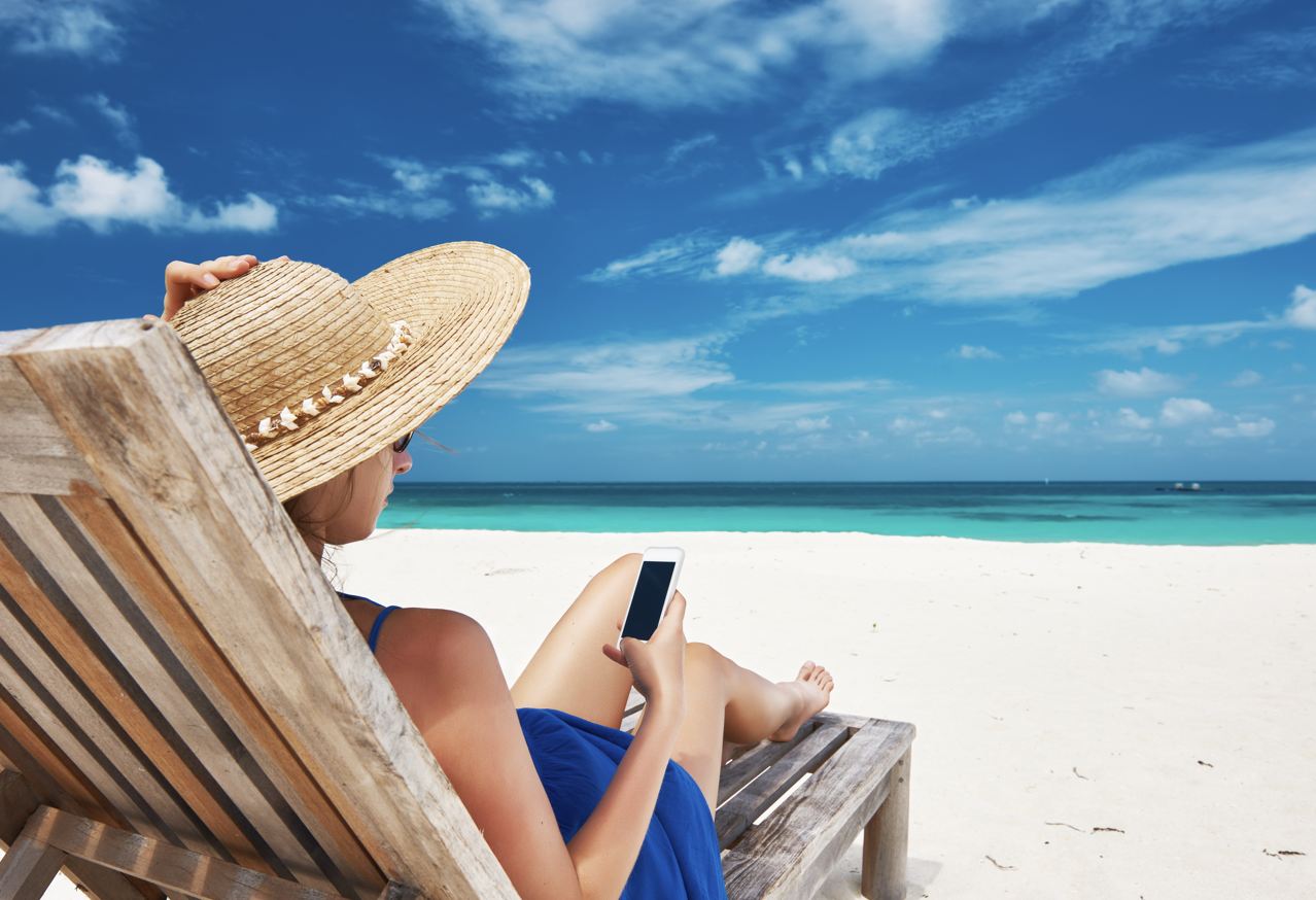 Mujer hablando por teléfono en la playa