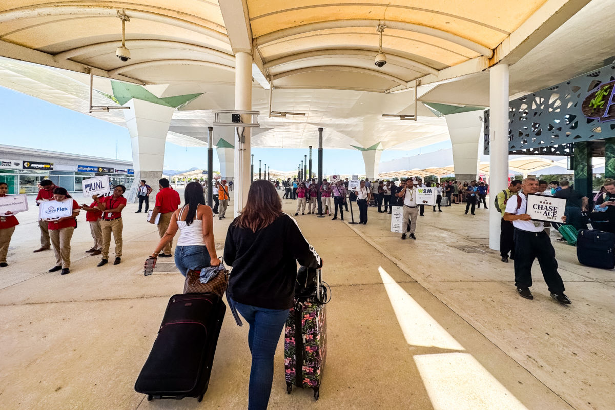 Personas que caminan hacia taxis y pastillas en el aeropuerto en el aeropuerto de Cancún