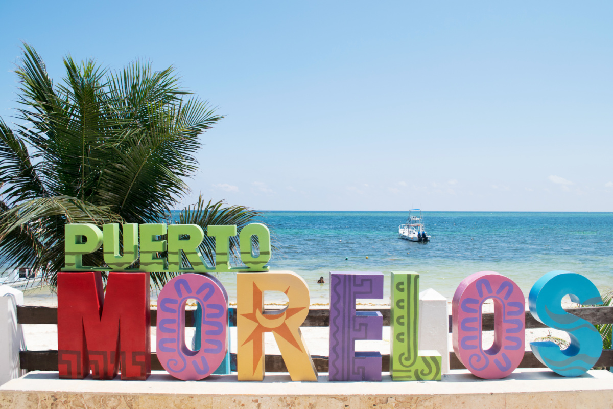 Barco a la deriva en el agua detrás del signo de Puerto Morelos