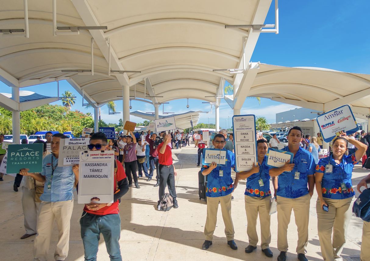 Conductores de llegadas del aeropuerto de Cancún con carteles