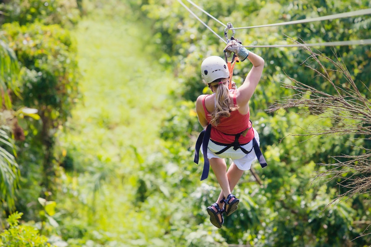 Mujer yendo a una aventura en tirolina en la jungla
