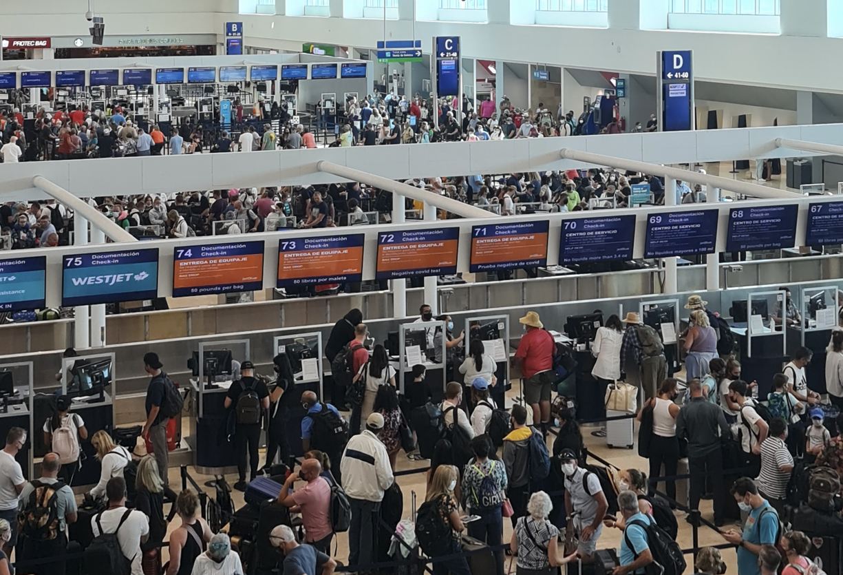 Viajeros de Cancún haciendo check-in para vuelos