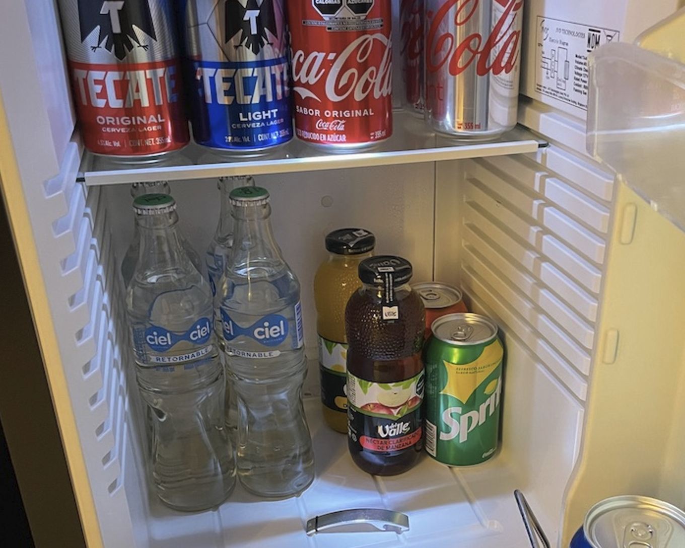 Cuatro botellas de agua en el refrigerador del mini bar en el Hilton Cancún Foto original de Trevor Kucheran