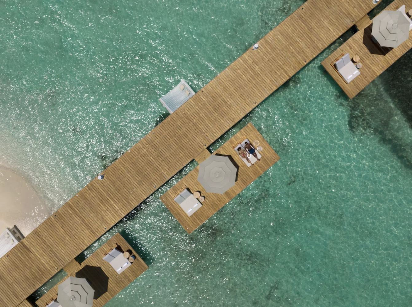 Pareja de Luna de Miel en muelle y sombrilla privada