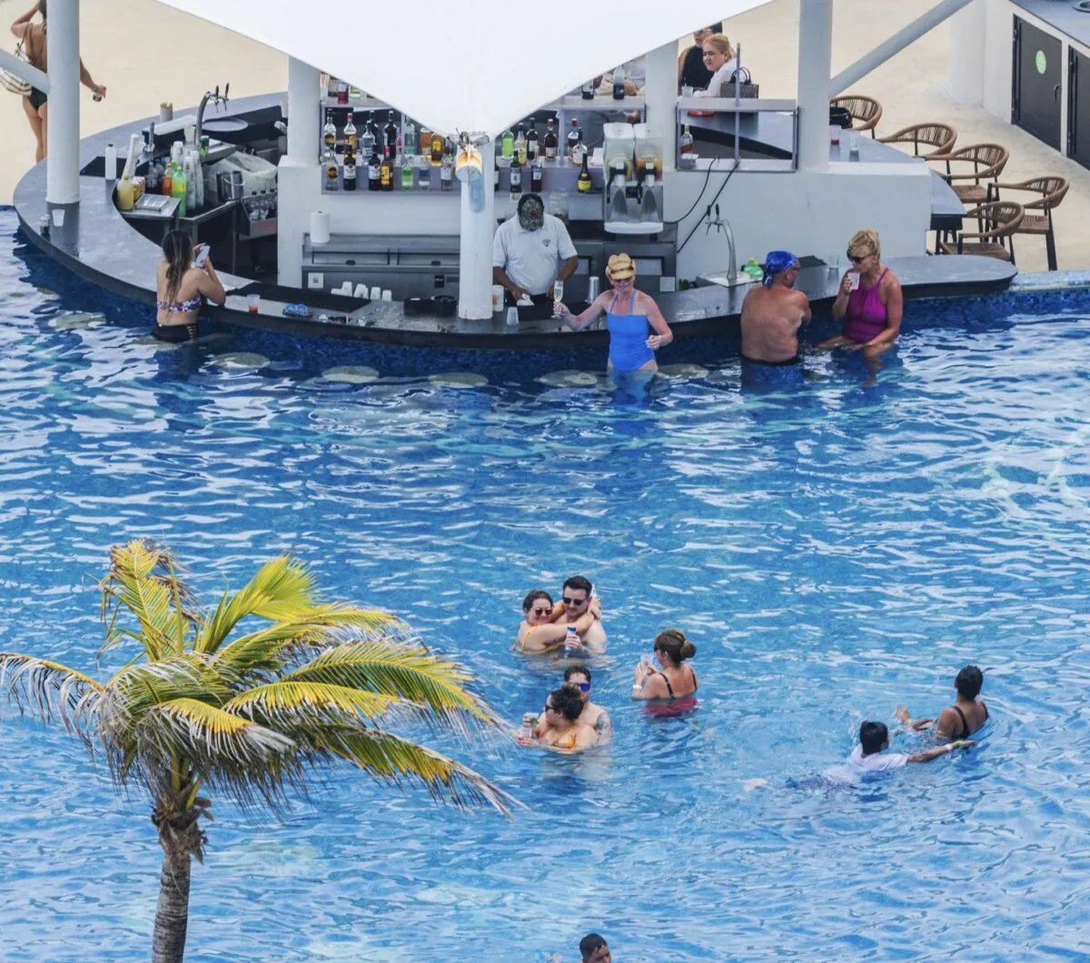 Piscina de Cancún y viajeros charlando con el barman.