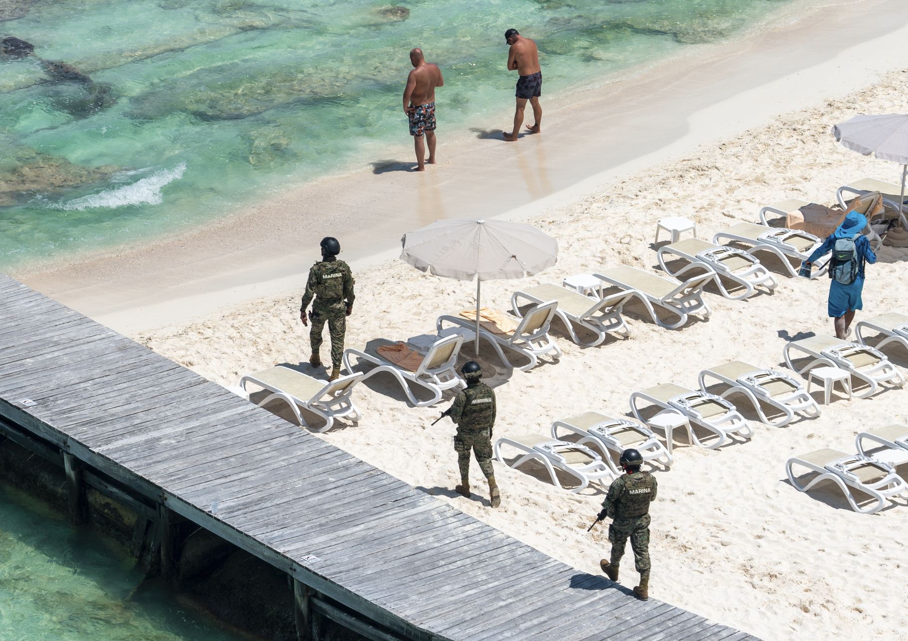 Soldados militares patrullan playa en Cancún
