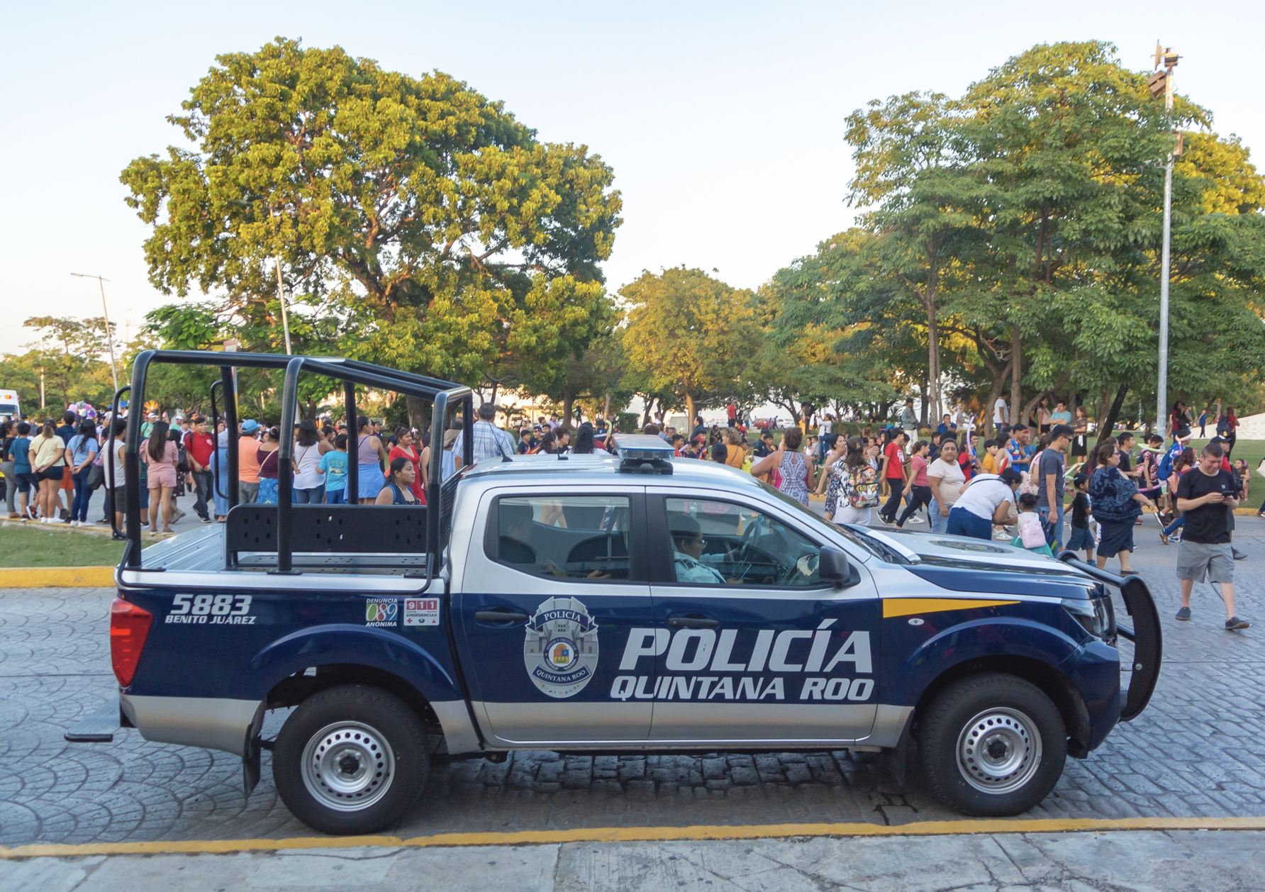 Policía en calle muy transitada y parque en Cancún