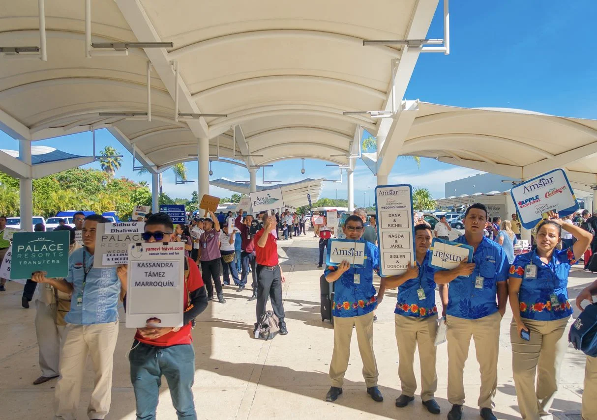 Conductores de llegadas del aeropuerto de Cancún con carteles