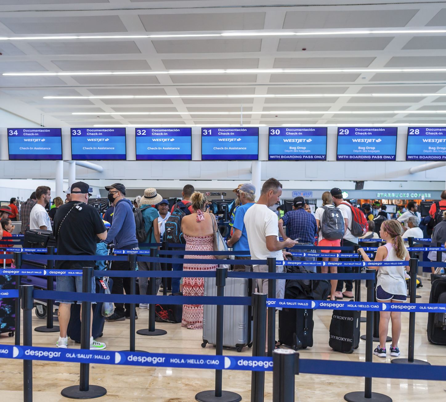 Los pasajeros esperan en línea para registrarse en busca de vuelos en el aeropuerto de Cancún